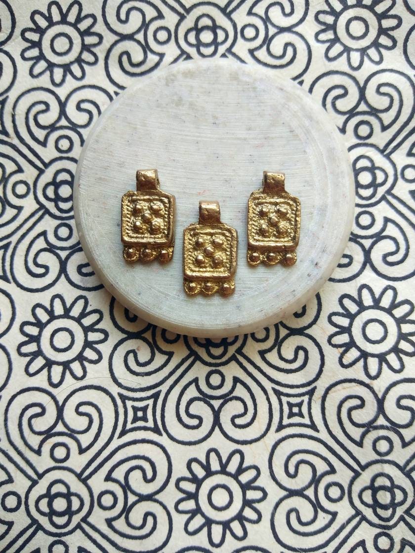 Antique Brass Charms – Detailed shot of an authentic, handcrafted antique brass charm for jewelry.