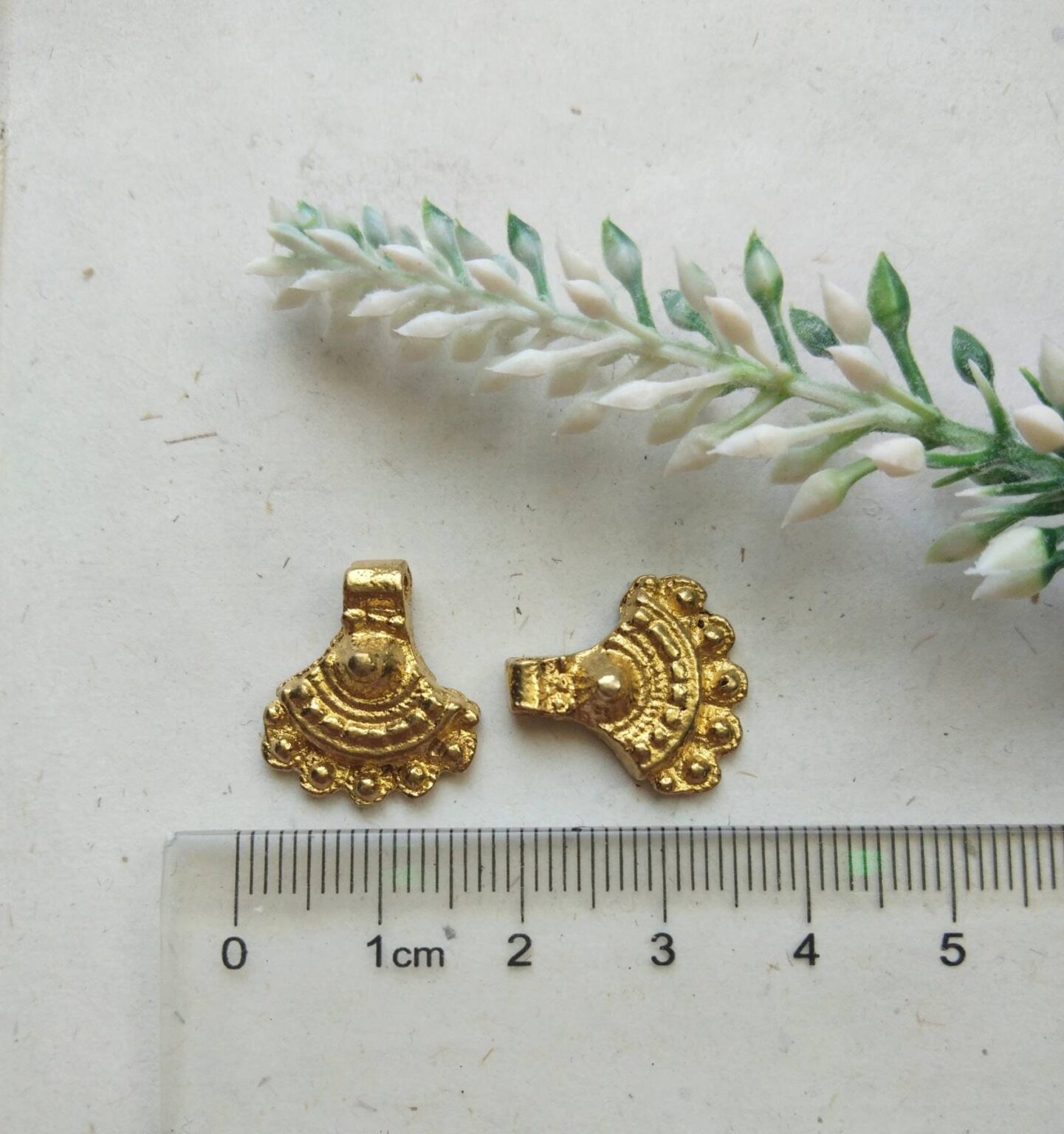 Brass Charms – Elegant display of brass charms in a boho style, ideal for creative accents.